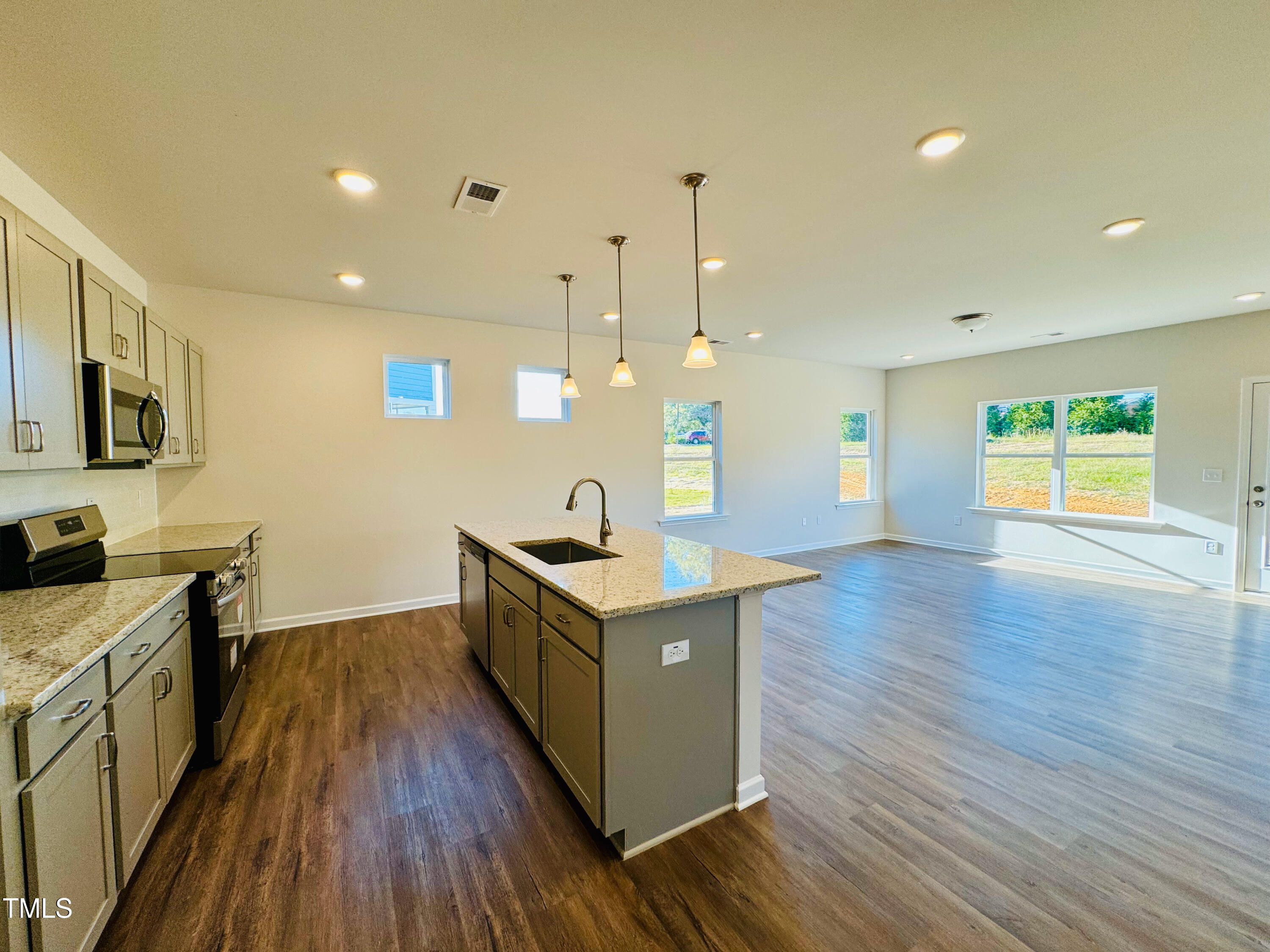 134 Commons Circle, Unit 232 Clayton, NC 27520 - Photo 4 of 37 a kitchen with a stove and a wooden floor