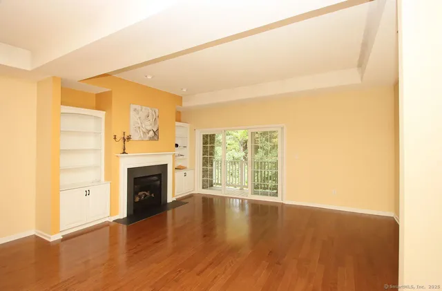 a view of an empty room with a fireplace and a window