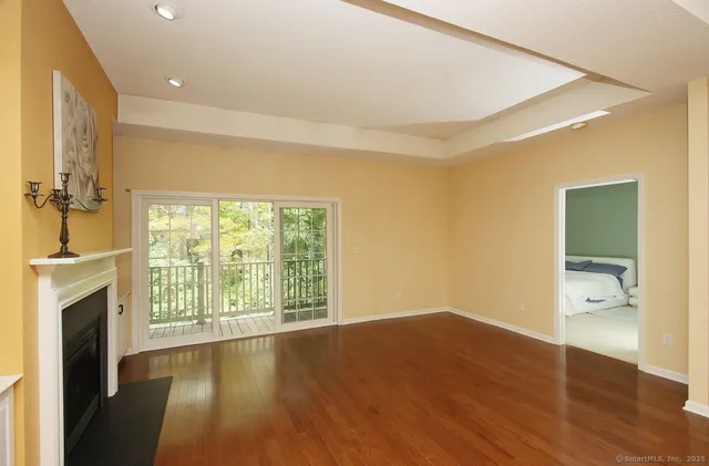 an empty room with wooden floor and a fireplace