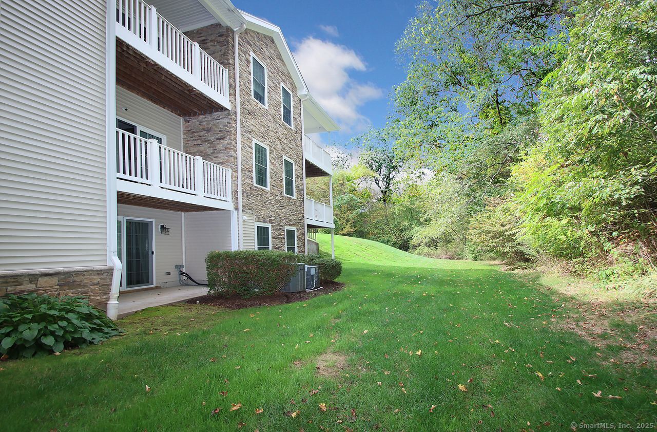 35 Todd Street, Unit 103 Hamden, CT 06518 - Photo 35 of 40 a view of a brick house with a yard and a large tree