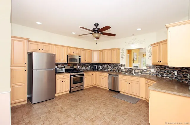 a kitchen with granite countertop a refrigerator oven a sink a stove a dining table and chairs