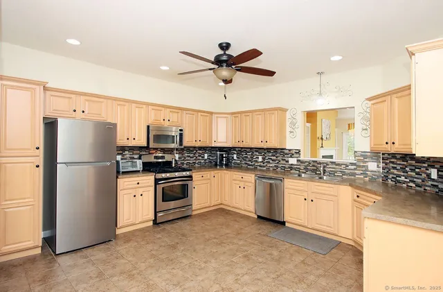 a kitchen with granite countertop a refrigerator oven a sink and cabinets