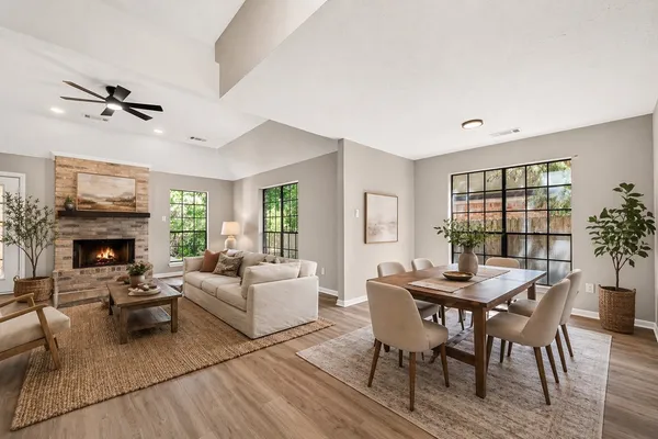 a living room with furniture a fireplace and a large window