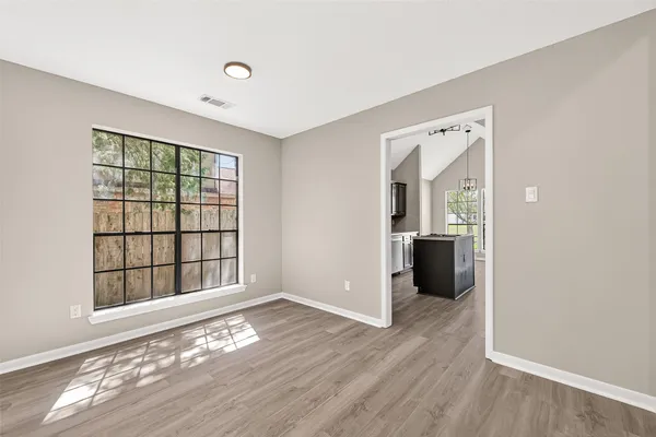 an empty room with a window and a fan