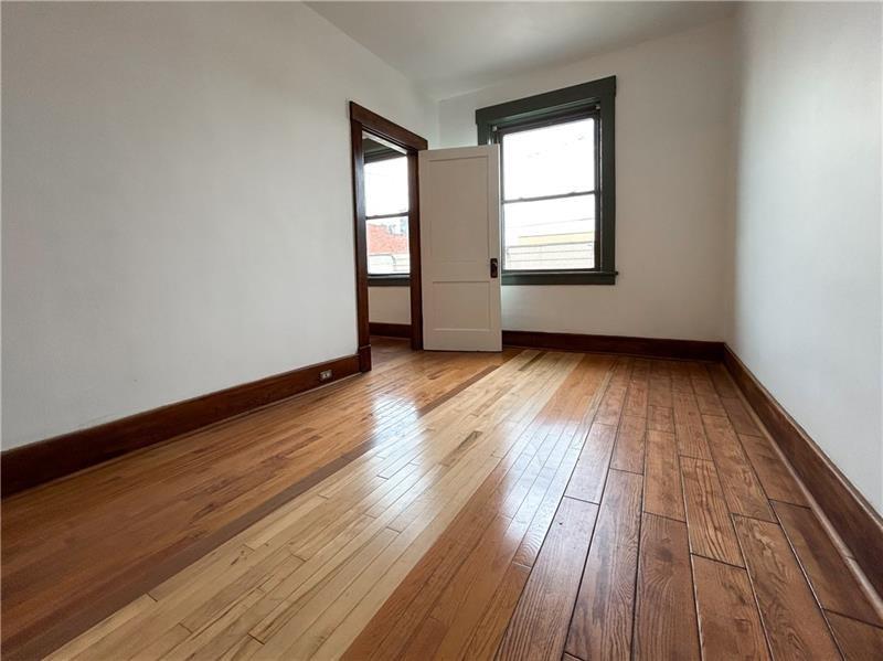 219 Brownsville Road Pittsburgh, PA 15210 - Photo 14 of 30 an empty room with wooden floor and windows