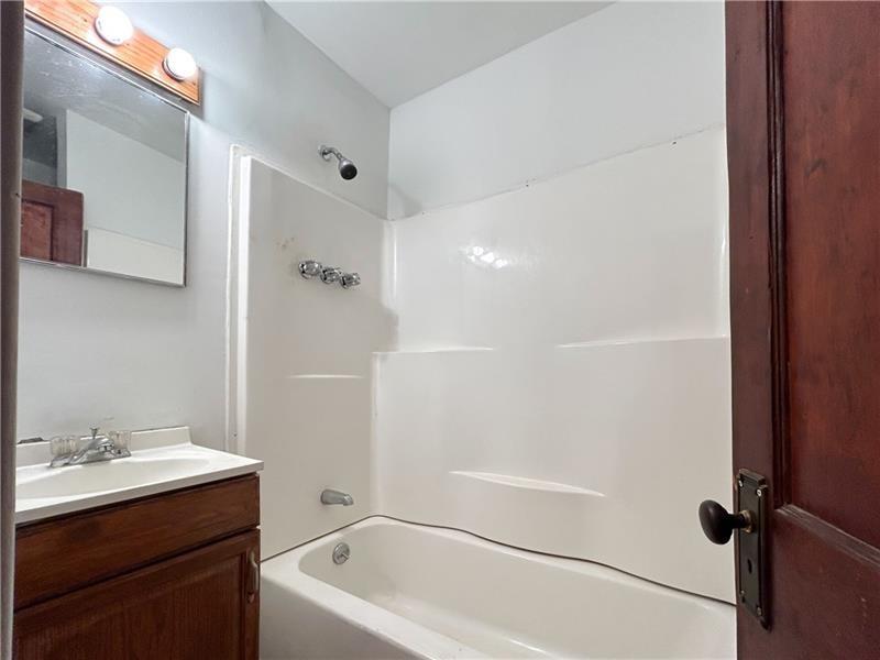 219 Brownsville Road Pittsburgh, PA 15210 - Photo 15 of 30 a bathroom with a bathtub shower sink vanity and a toilet