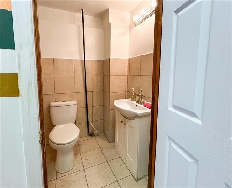 219 Brownsville Road Pittsburgh, PA 15210 - Photo 23 of 30 a bathroom with a sink toilet and a mirror