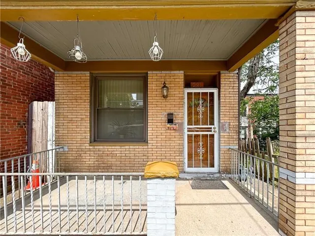 a brick building with a bench and trees
