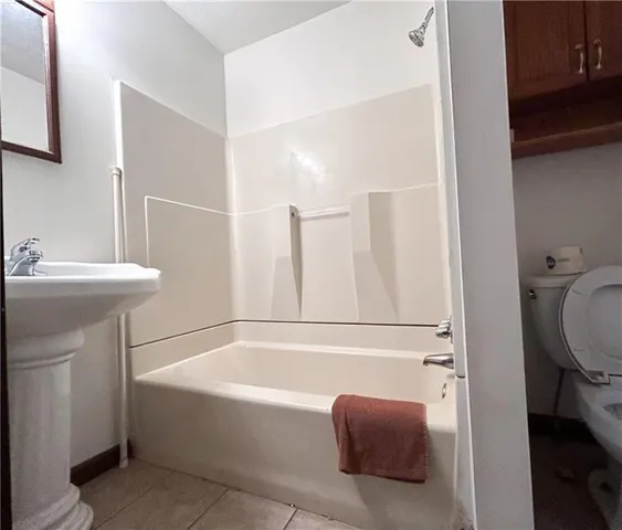 an empty room with wooden floor fireplace and windows