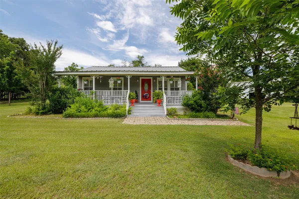 a front view of house with yard and green space