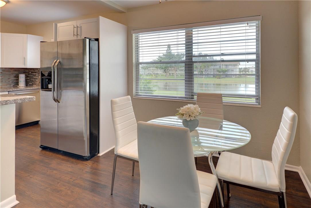144 Dorset D, Unit 144 Boca Raton, FL 33434 - Photo 1 of 20 a kitchen with stainless steel appliances a refrigerator a table and chairs