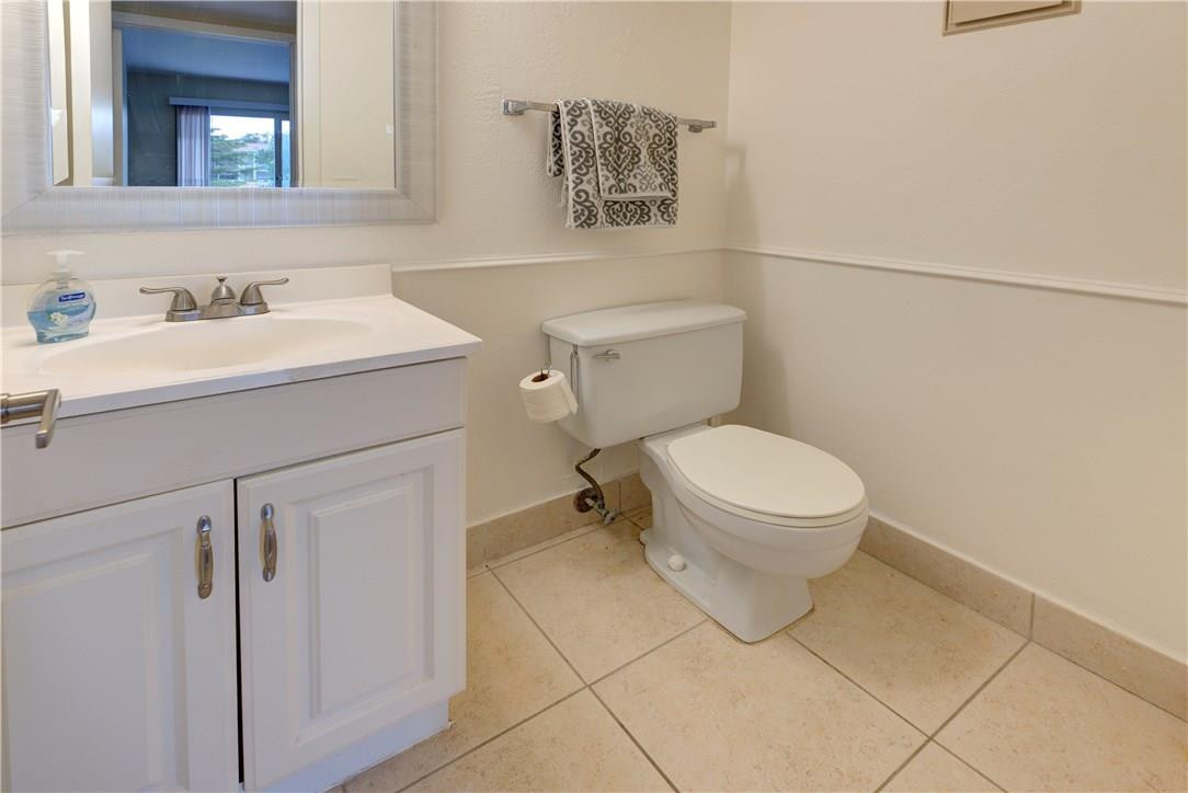 144 Dorset D, Unit 144 Boca Raton, FL 33434 - Photo 12 of 20 a bathroom with a toilet sink and mirror