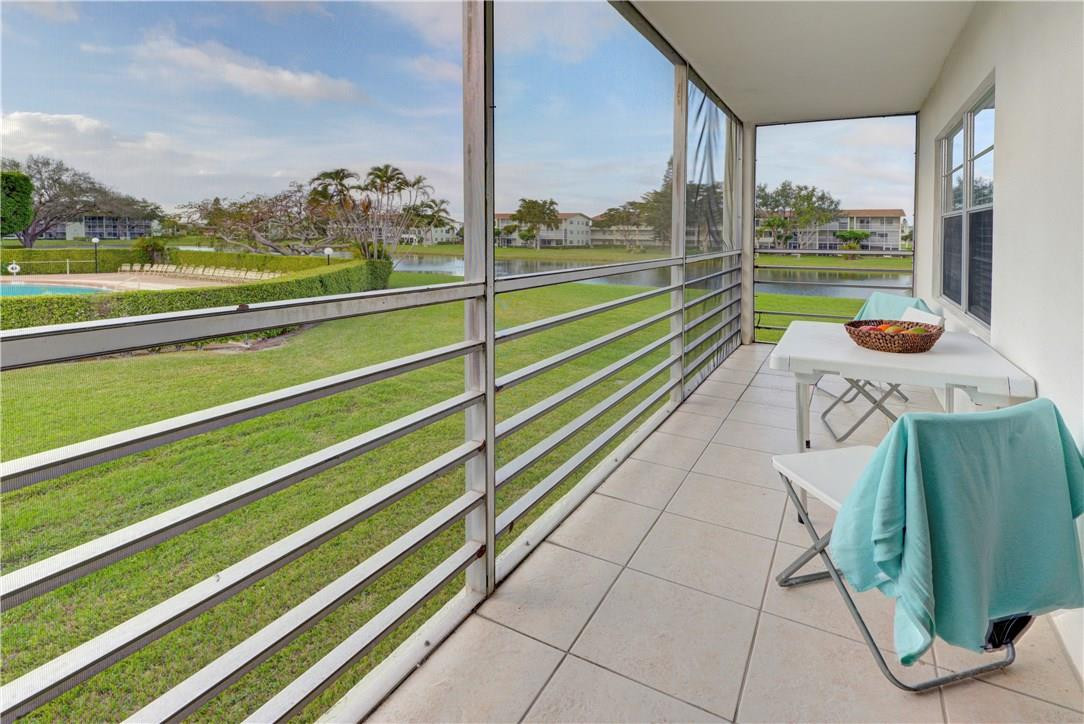 144 Dorset D, Unit 144 Boca Raton, FL 33434 - Photo 16 of 20 a view of a balcony with floor to ceiling windows with wooden floor