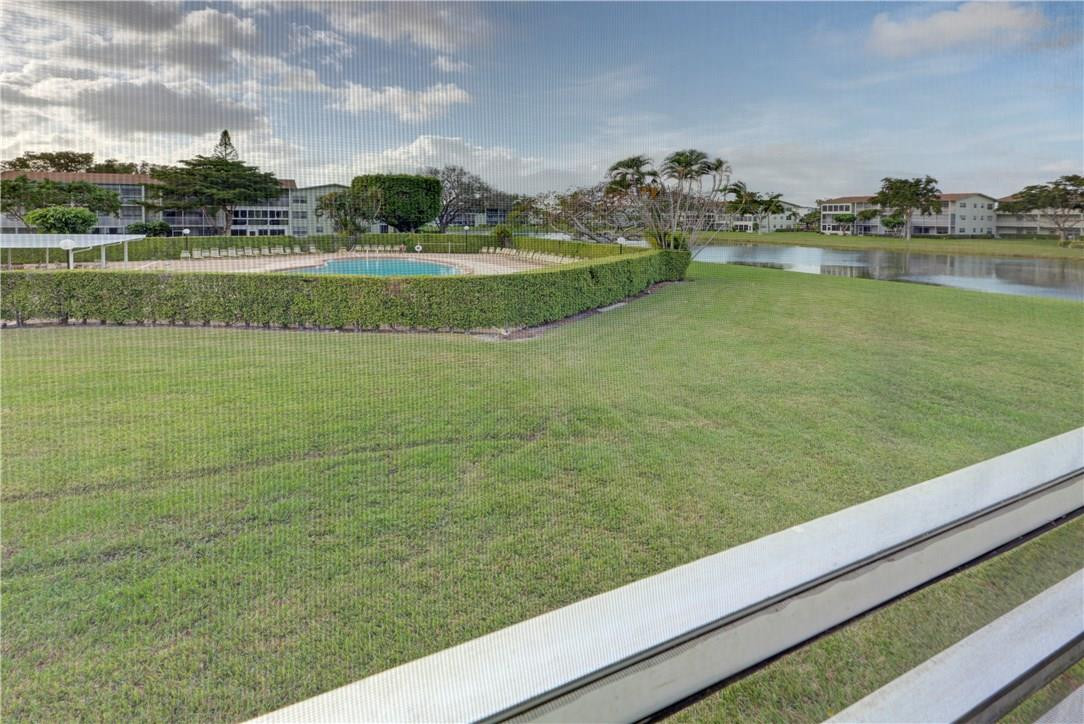 144 Dorset D, Unit 144 Boca Raton, FL 33434 - Photo 17 of 20 a view of a lake with houses in the back