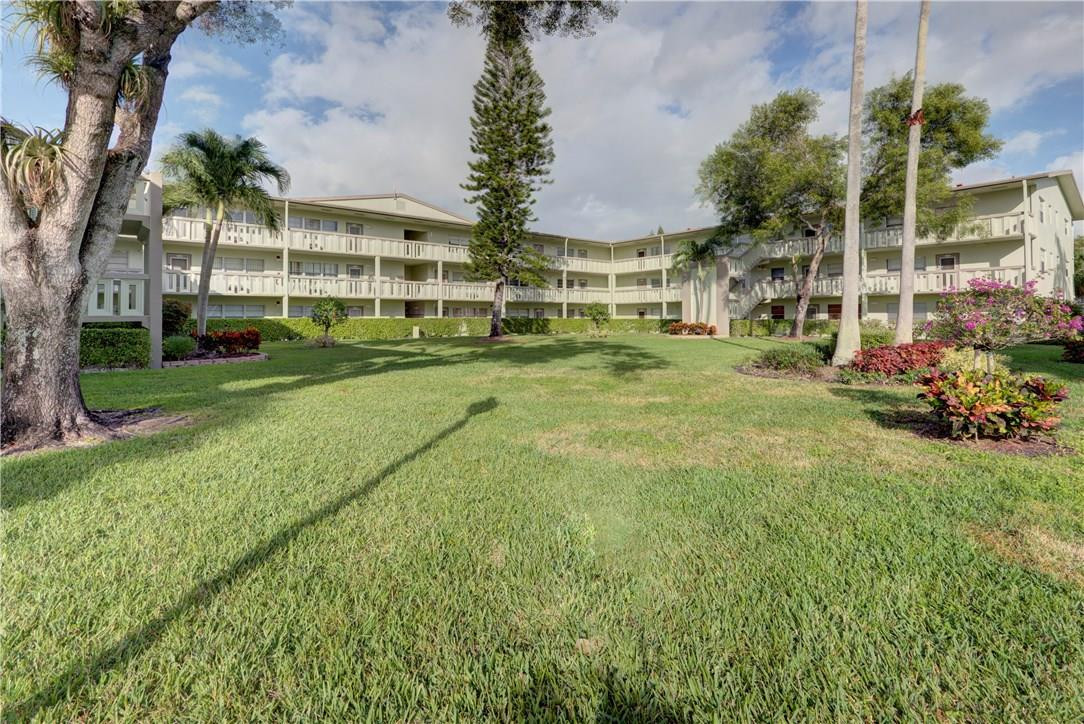 144 Dorset D, Unit 144 Boca Raton, FL 33434 - Photo 18 of 20 a view of an apartment with a garden and trees