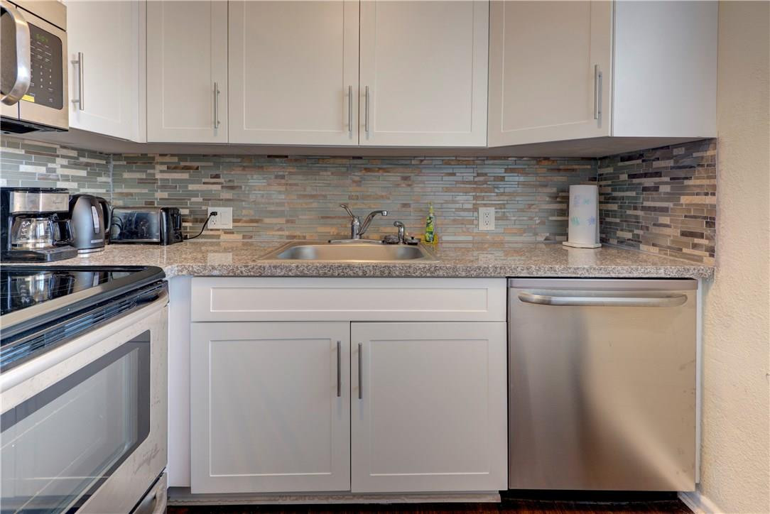 144 Dorset D, Unit 144 Boca Raton, FL 33434 - Photo 5 of 20 a kitchen with granite countertop cabinets stainless steel appliances and sink