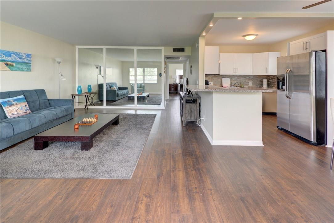 144 Dorset D, Unit 144 Boca Raton, FL 33434 - Photo 6 of 20 a living room with stainless steel appliances kitchen island granite countertop wooden floors and couches