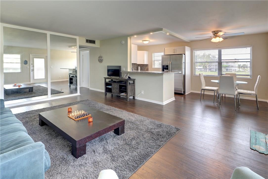 144 Dorset D, Unit 144 Boca Raton, FL 33434 - Photo 7 of 20 a living room with dining room and kitchen view with wooden floor