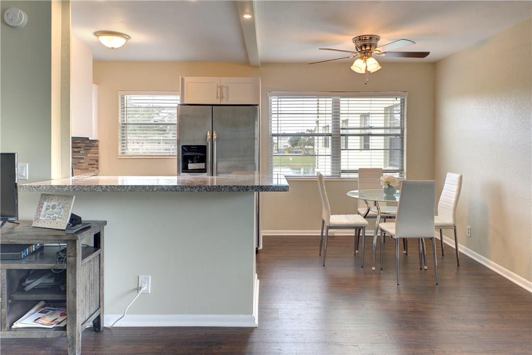 144 Dorset D, Unit 144 Boca Raton, FL 33434 - Photo 8 of 20 a view of a dining room with furniture a chandelier and wooden floor