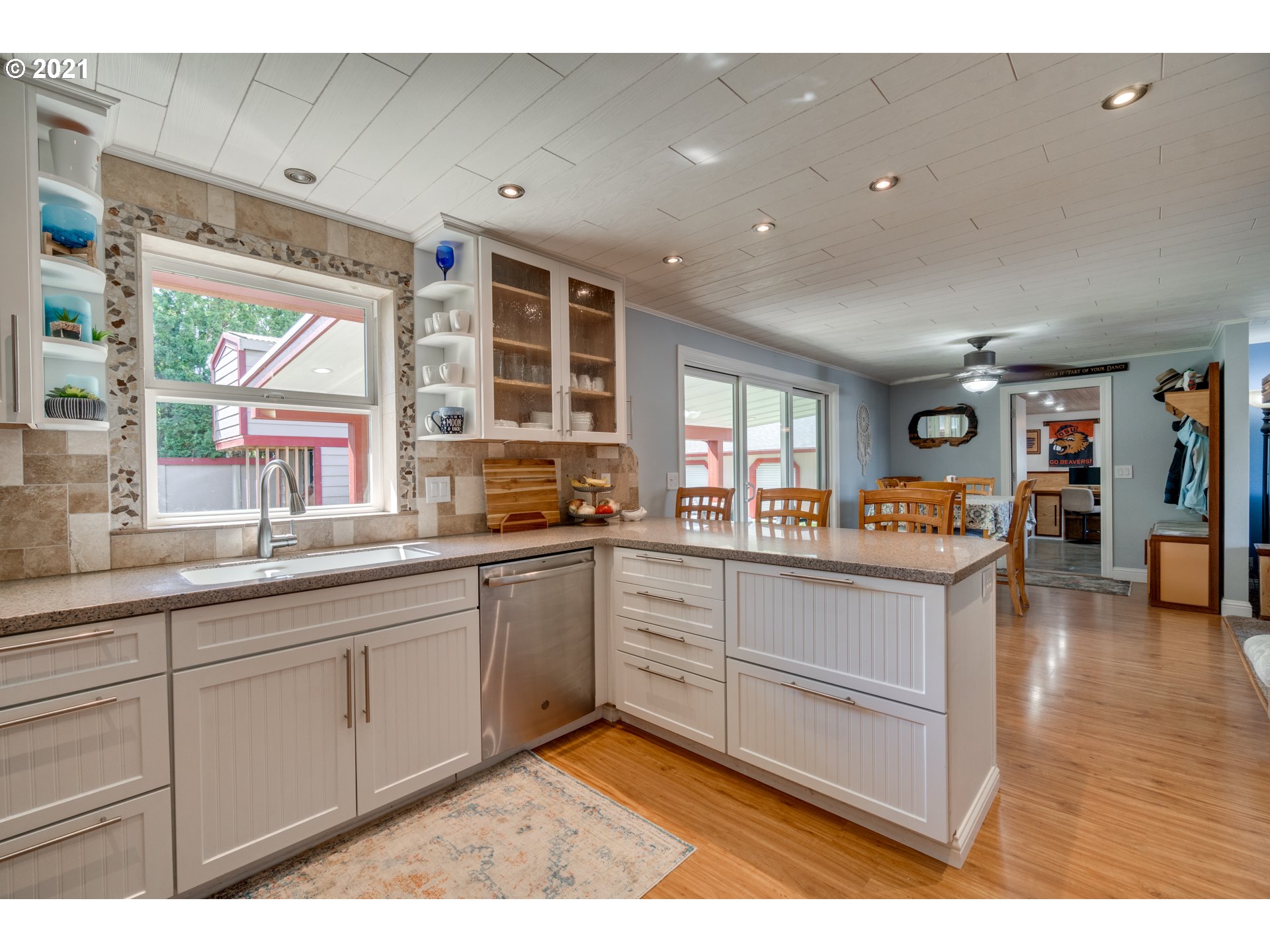 3132 1st Street Hubbard, OR 97032 - Photo 14 of 32 a kitchen with granite countertop a stove a sink a dining table and chairs