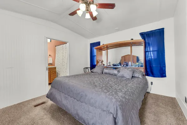 a bedroom with a large bed and a chandelier