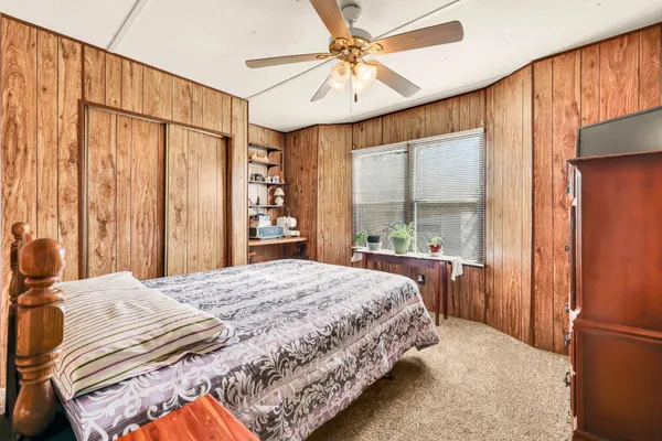 a bedroom with a large bed and a chandelier