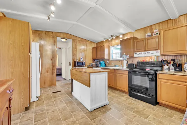 a kitchen with stainless steel appliances granite countertop a stove a sink and a refrigerator