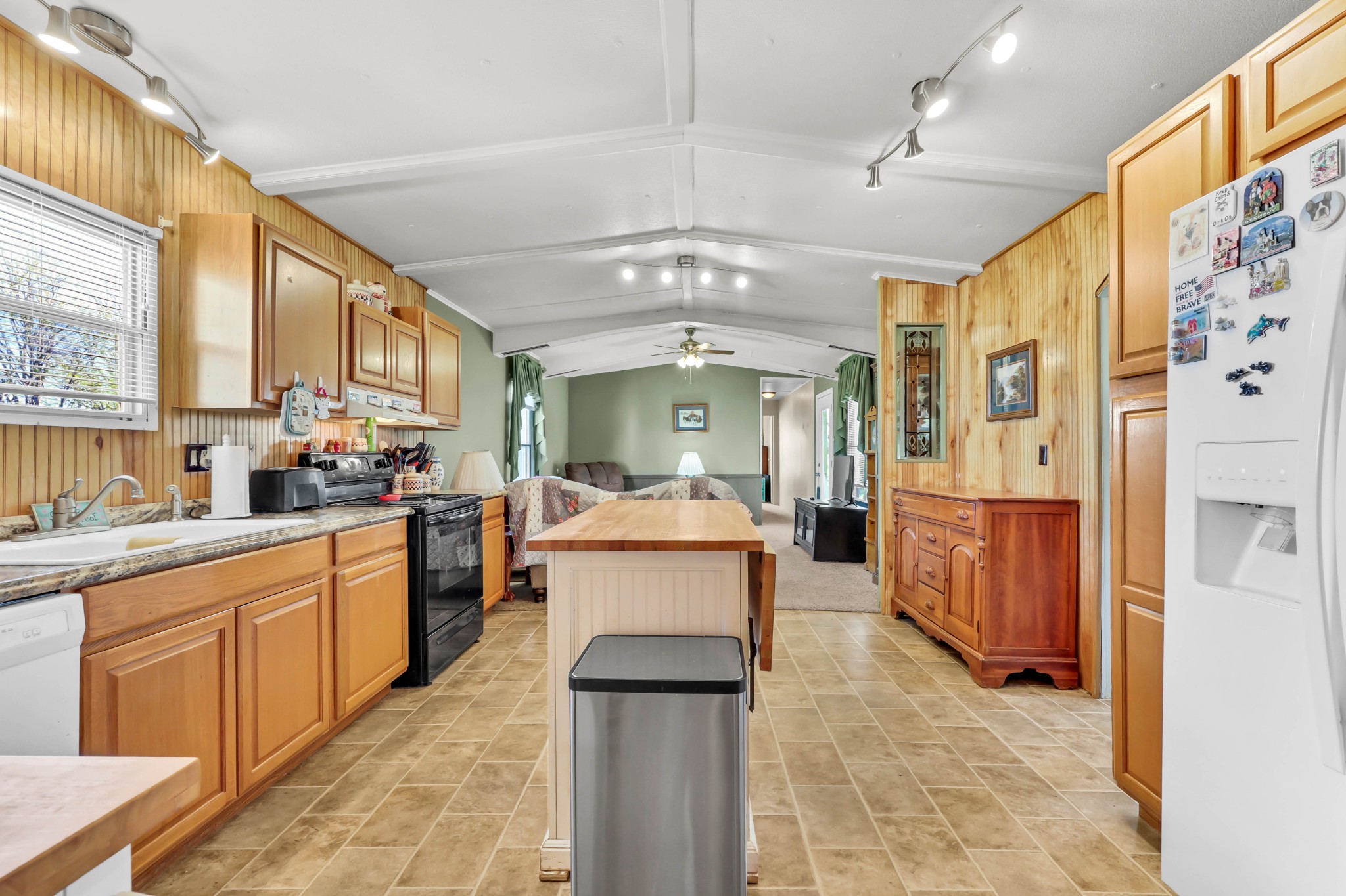 1765 Woolworth Road Erin, TN 37061 - Photo 7 of 34 a large white kitchen with stainless steel appliances kitchen island granite countertop a lot of counter space and a window
