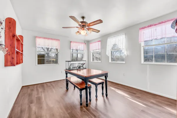 a dining room with furniture a window and wooden floor