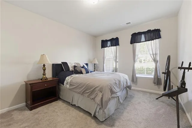 a bedroom with a bed and a flat tv screen on the dresser