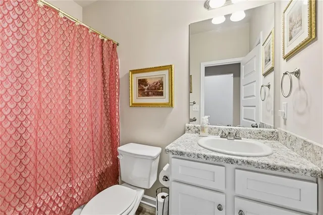 a bathroom with a granite countertop sink mirror vanity and toilet