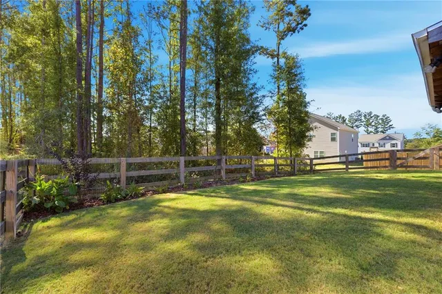 a view of swimming pool with outdoor seating and trees in the background