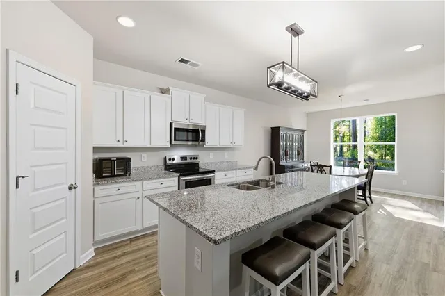a kitchen with granite countertop stainless steel appliances a stove a sink and a microwave