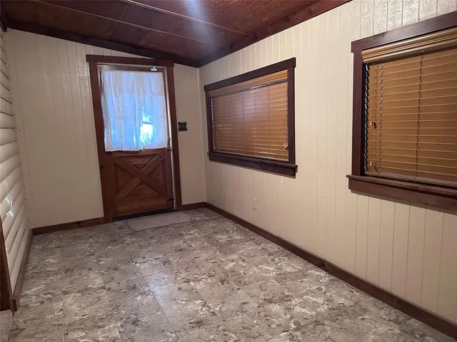 a view of an empty room with closet and windows