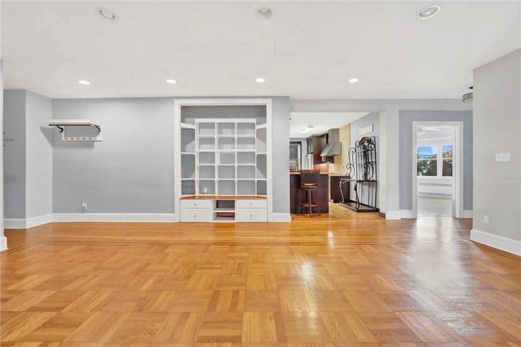 9615 Shore Road, Unit 3A Brooklyn, NY 11209 - Photo 3 of 14 a view of an empty room with wooden floor and a kitchen