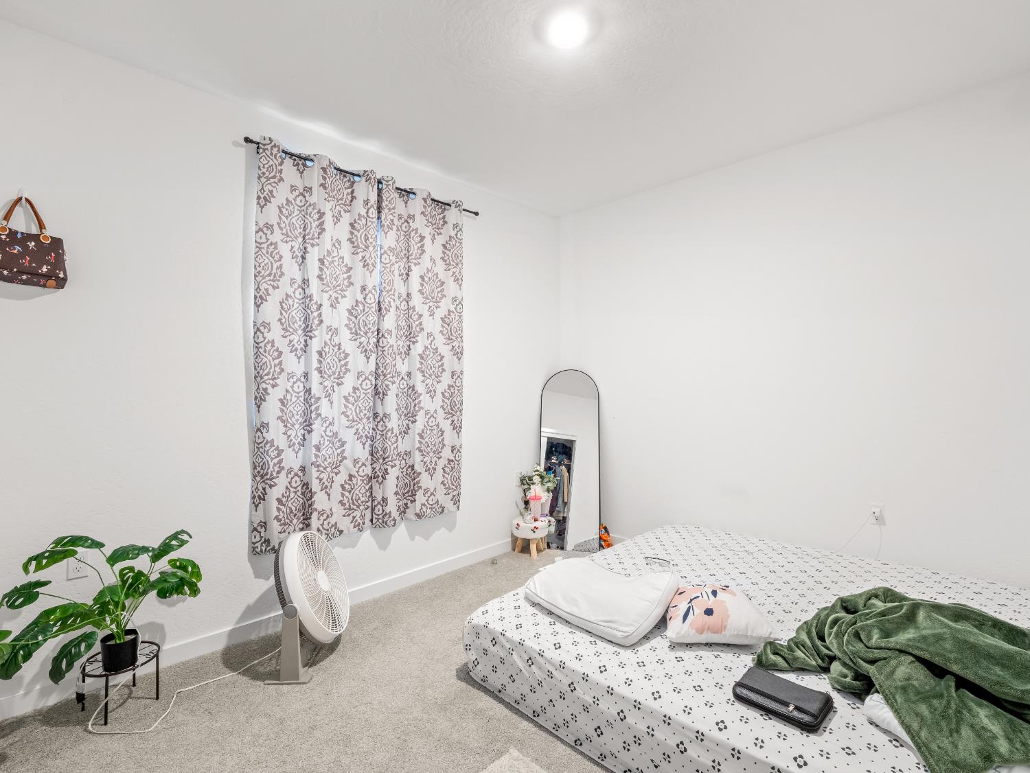 5958 West Austin Way Fresno, CA 93722 - Photo 15 of 18 a bedroom with a bed and a potted plant