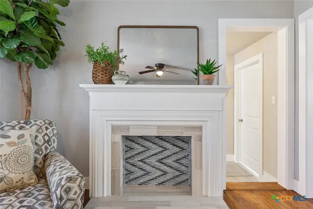 a living room with a fireplace and potted plant