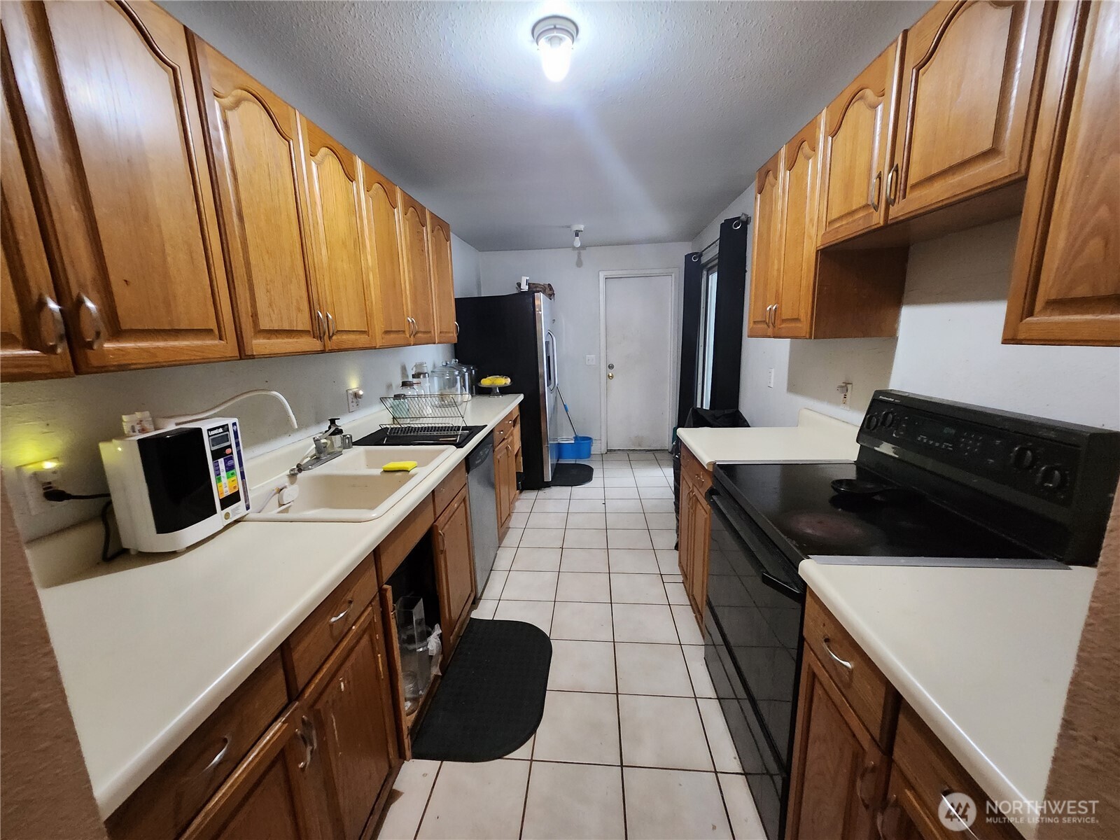 2019 Southwest 318th Place, Unit 4C Federal Way, WA 98023 - Photo 21 of 23 a kitchen with a sink a stove and a refrigerator