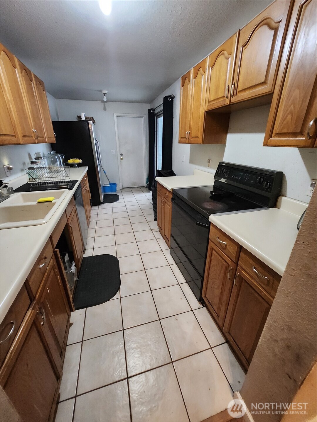 2019 Southwest 318th Place, Unit 4C Federal Way, WA 98023 - Photo 5 of 23 a kitchen with granite countertop a stove sink and cabinets