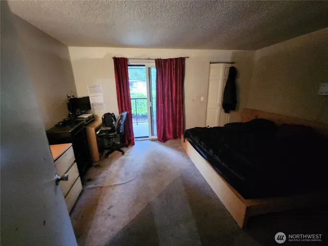 a bedroom with a bed and dresser with mirror