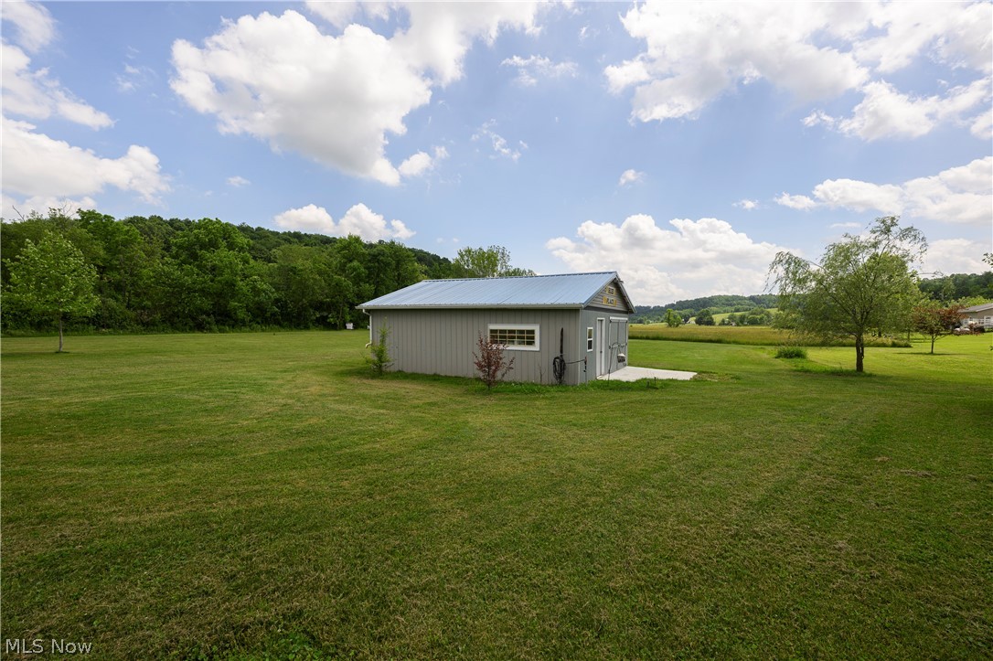 9427 Stonecreek Road Southwest Newcomerstown, OH 43832 - Photo 7 of 29 Freestanding gray outbuilding featuring a metal roof and an exterior access door
