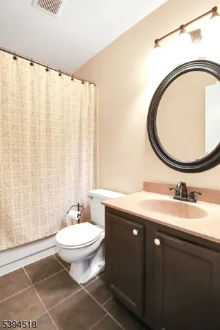 a bathroom with a granite countertop toilet a sink and a mirror