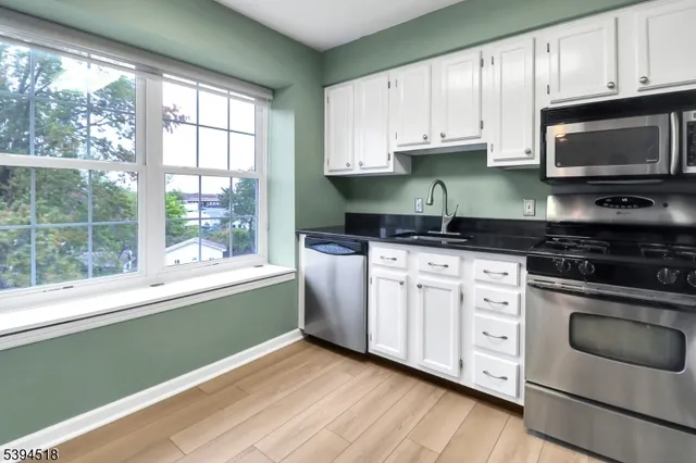 a kitchen with granite countertop a stove a sink and a microwave