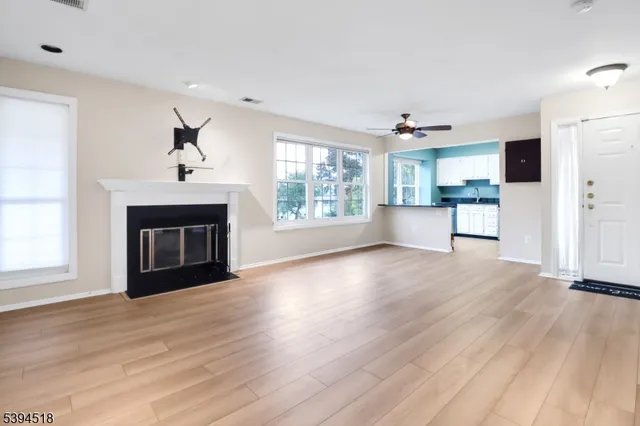 a view of an empty room with a fireplace and a window