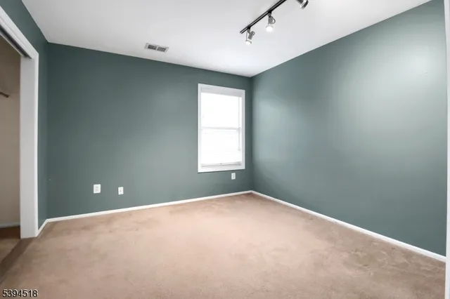 a view of a big room with windows and chandelier fan