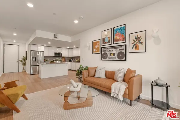 a living room with furniture kitchen and a table
