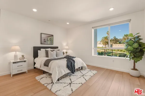 a spacious bedroom with a bed and a painting on the wall