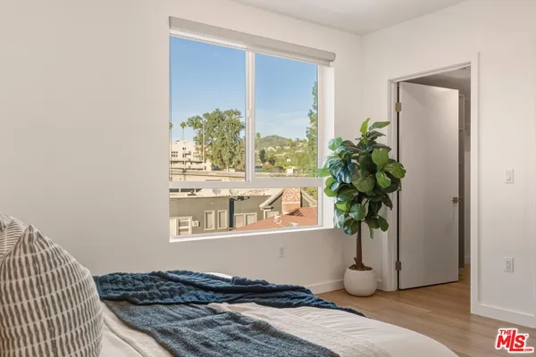 a blue bed sitting in a bedroom next to a window