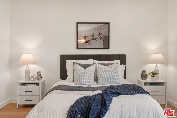a bedroom with a bed and lamp on dresser