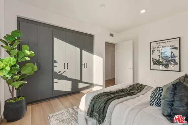a bedroom with bed and a potted plant